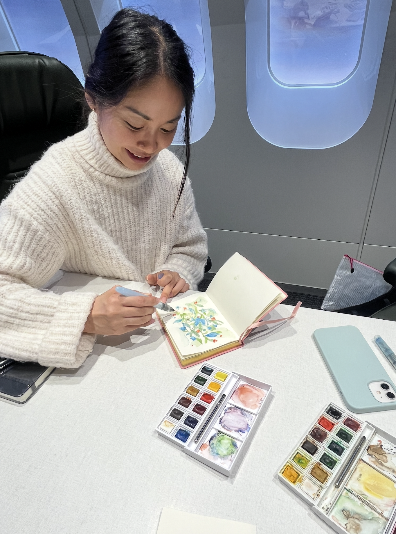 A designer painting watercolours in the plane-themed room